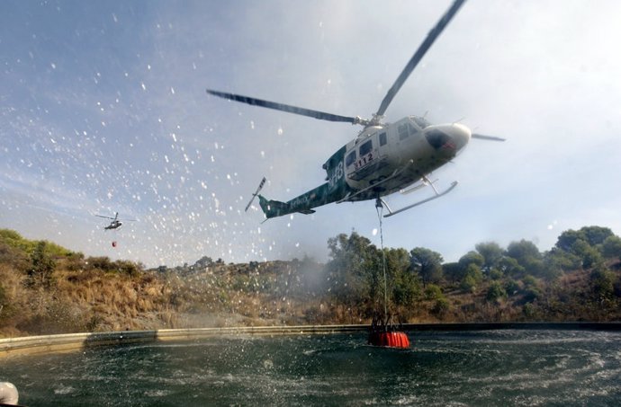 Helicóptero en proceso de repostaje de agua contra incendios