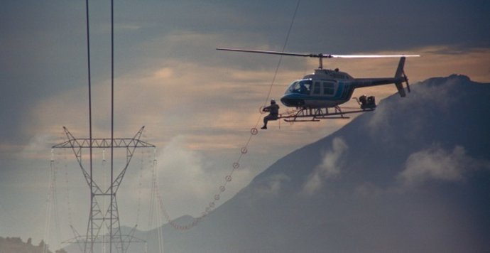 Helicóptero de Red Eléctrica de España señalizando con espirales los tendidos