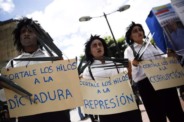 Opposition supporters hold placards during a gathering to protest against Venezu