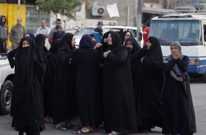 Mujeres iraquíes ante el escenario de un coche bomba en Bagdad