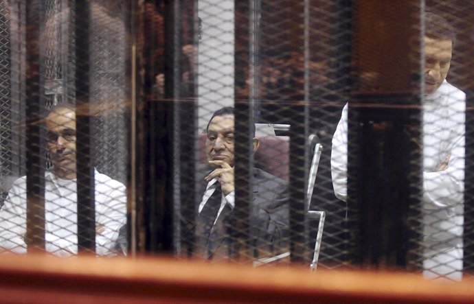 Hosni Mubarak sentado al lado de sus hijos
