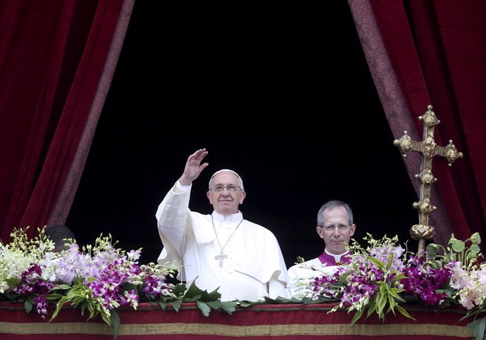 Pope Francis waves as he delivers a "Urbi et Orbi" message from the balcony over