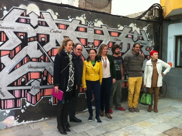 Carolina León con Inmaculada Anaya (Cúrcuma) con el mural que se va a usar