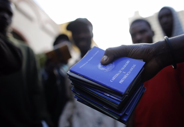 A man shows the Work and Social Security documents of Haitian immigrants at the 