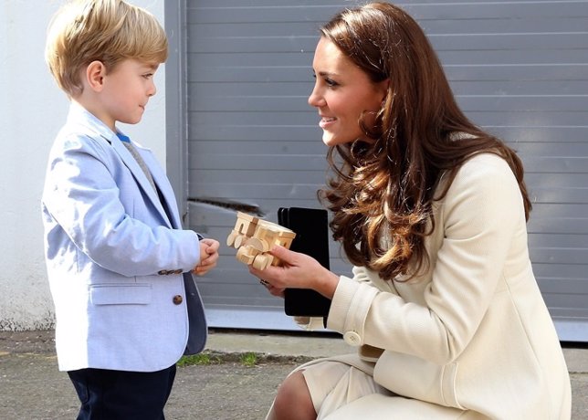 The Duchess of Cambridge is presented with a train for Prince George by actor Ol