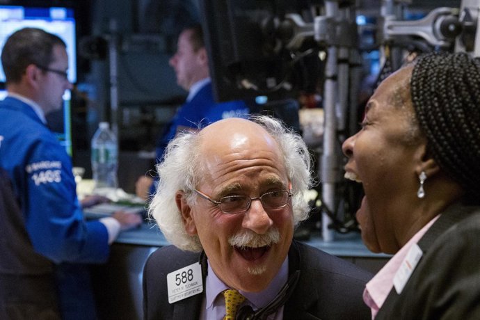 Traders laugh as they work on the floor of the New York Stock Exchange as the ma