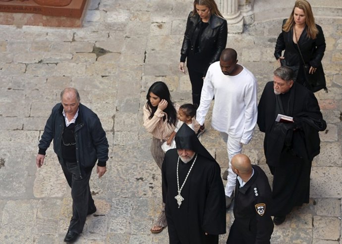 U.S. Reality TV star Kim Kardashian (C) holds her toddler daughter North West as