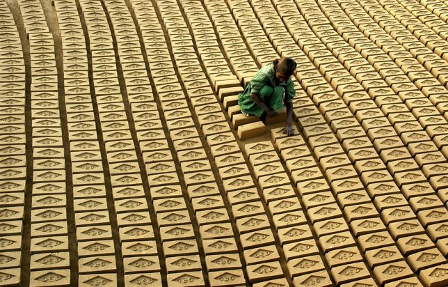 Una niña india trabaja colocando ladrillos 