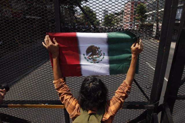A university student holds the Mexican flag during a protest against Enrique Pen