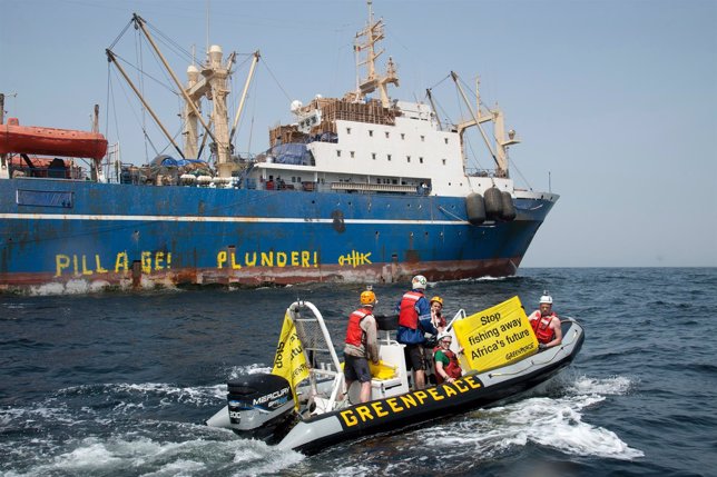 Activists from the Greenpeace ship's Arctic Sunrise holding banner in front of p