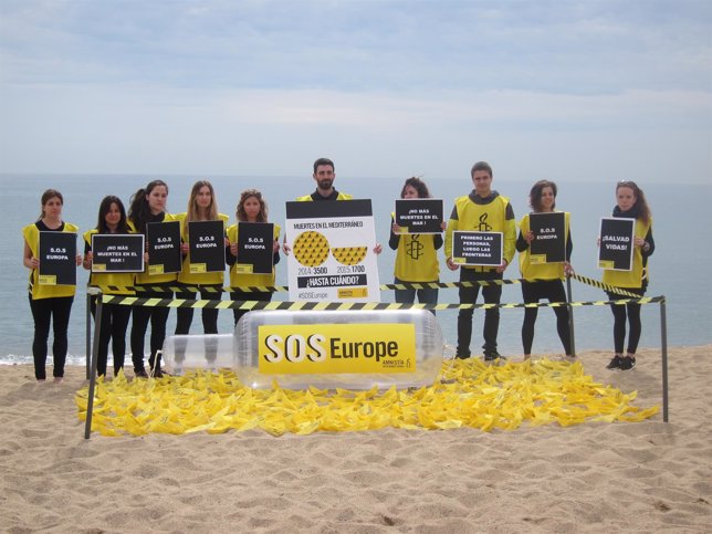 Activistas de AI realizan una acción en la playa de St.Sebastià de Barcelona