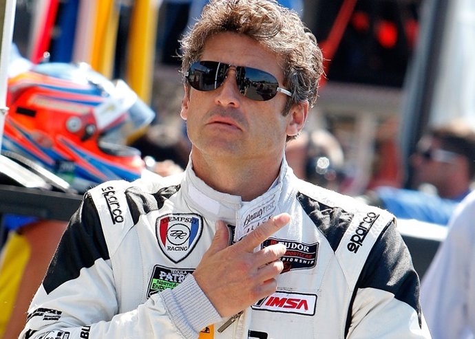 Patrick Dempsey walks through the paddock before pra