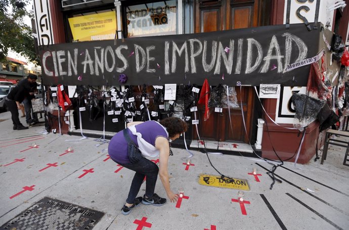 Herminia Jensezian places candles on a sidewalk during a commemoration marking t