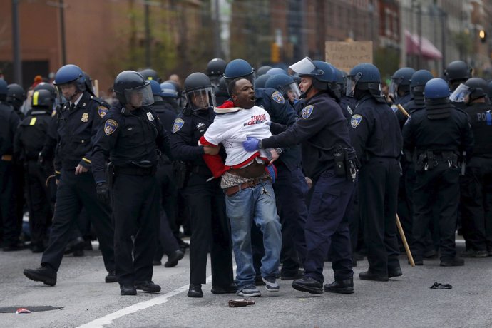 Police detain a protester at a rally to protest the death of Freddie Gray who di