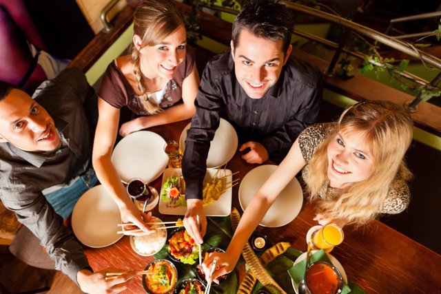 Jóvenes comensales compartiendo mesa en Tailandia