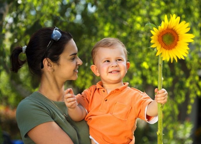 Mutter und Kind im Garten. / Two years old baby boy and mother enjoy the summer 