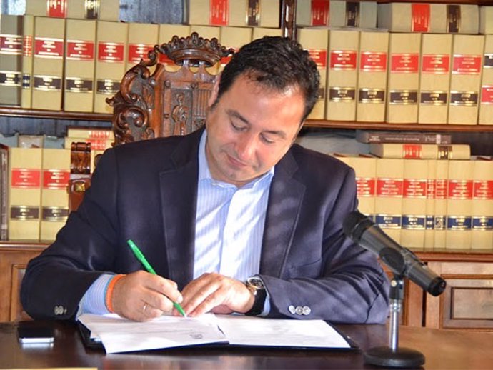El alcalde firma el convenio.