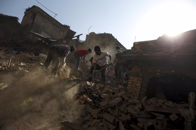 Local residents clear the rubble from their homes which were destroyed after las