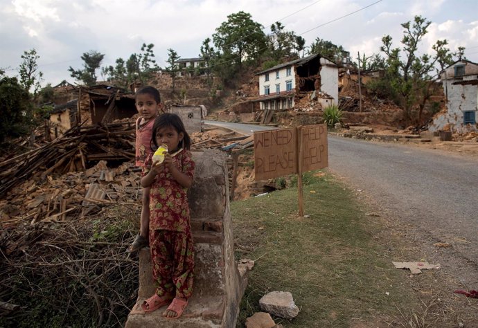 Niños delante de casa derruida en Nepal  tras terremoto