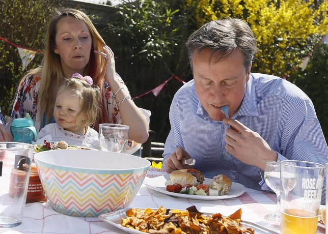 El primer ministro británico, David Cameron, come un perrito caliente