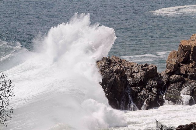 A wave crashes against the rocks at Azul beach in Coyuca de Benitez