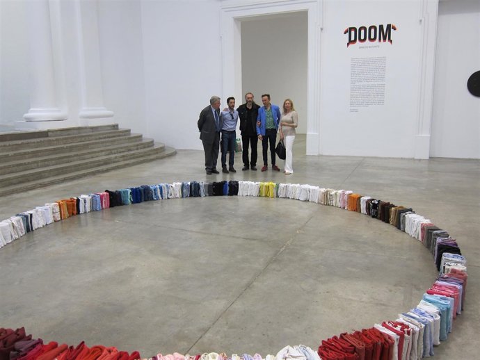 Los cuatro organizadores, junto a una de las propuestas de la exposición