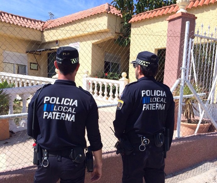 Dos agentes de Policía Local junto a la valla de la residencia.