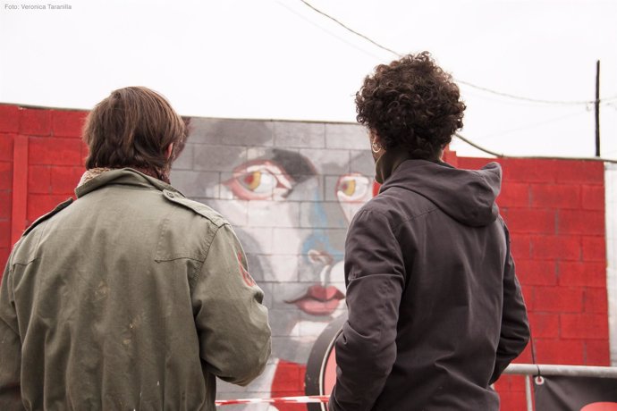 Dos vecinos ante un mural del festival Us Barcelona