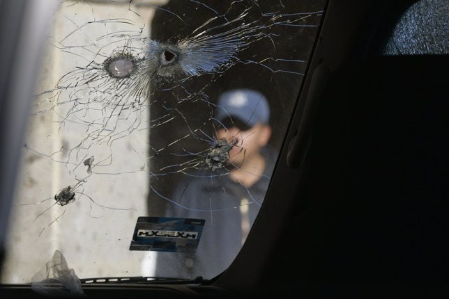 Bullet holes are seen on a window of a police car after various clashes between 