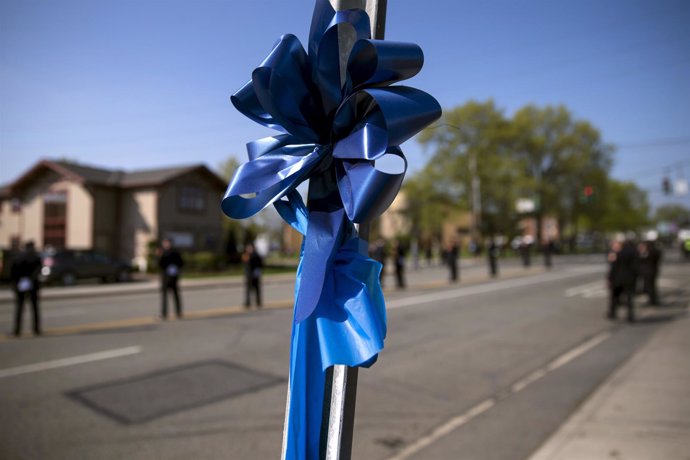 Blue ribbon is seen tied to a sign post outside the funeral service for slain Ne