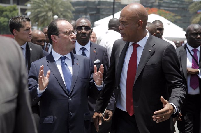 French President Hollande and Haiti's President Martelly chat as they walk in Ch