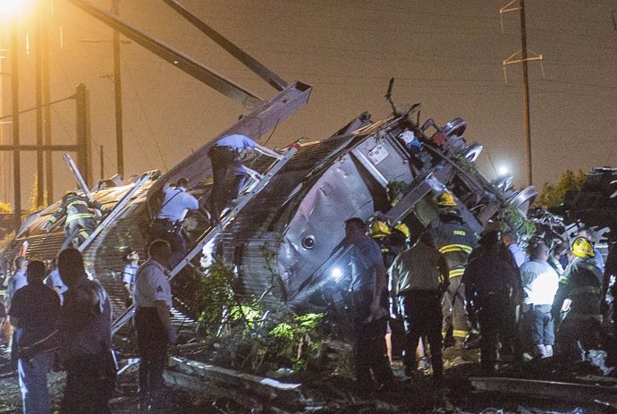 Rescue workers search for victims in the wreckage of a derailed Amtrak train in 