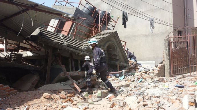Un edificio derruido en Katmandú es inspeccionado por varias personas