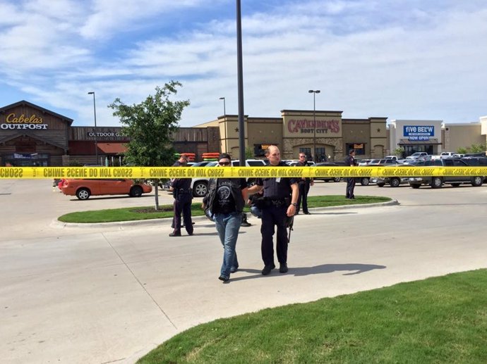 Police escort a man at the scene of a shooting in Waco