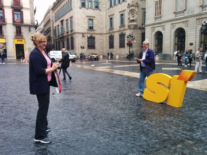 Unos turistas se fotografían con el material de campaña de ERC en Barcelona
