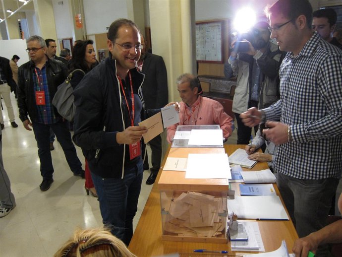 César Luena muestra sus sobres justo antes de introducirlos en las urnas