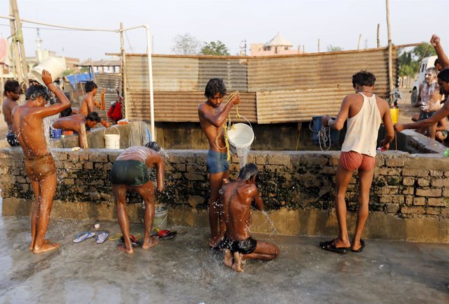 Construction labourers bathe at a well early morning before heading out for thei