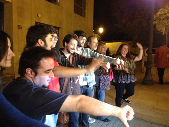 Miembros de Podemos se fotografían con el pulgar hacia abajo ante el PPCV