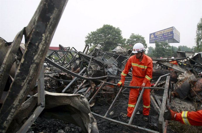 Los bomberos trabajan entre los restos de una residencia incendiada en Henan