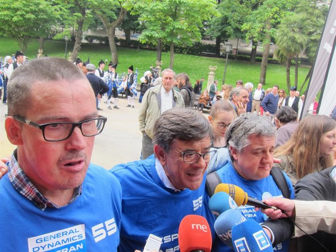 Ramos, flanqueado por dos de los 55 despedidos de la fábrica de armas. 