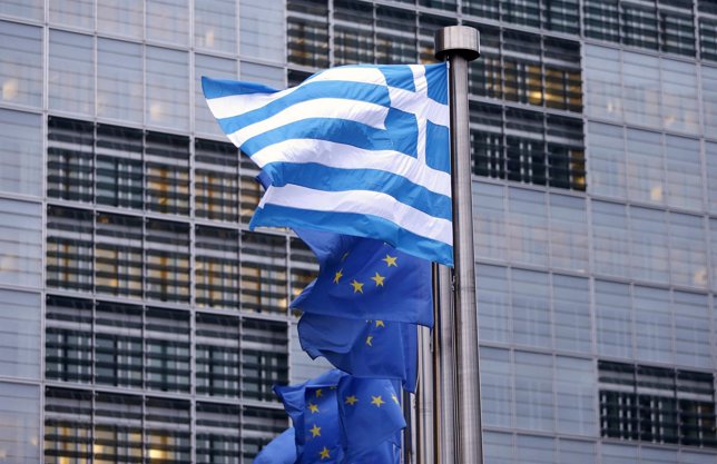 A Greek national flag flies next to EU flags outside the EU Commission headquart