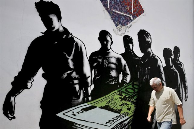 A man makes his way past graffiti 