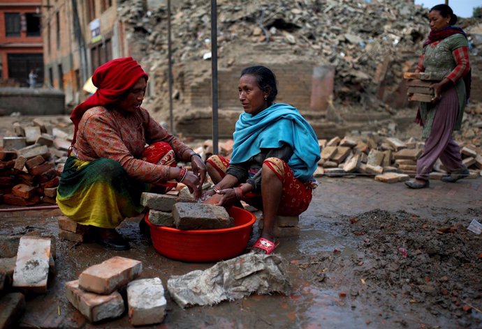 Women wash usable bricks which they found from collapsed houses after the earthq