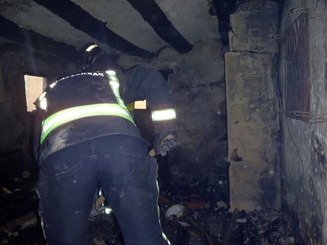 Un bombero trabajando en la casa que se ha incendiado