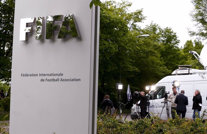 Members of the media stand in front of the entrance of the FIFA headquarters in 