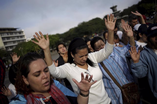 Members of a religious group pray for the country's political and social peace, 