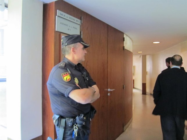 Un policía vigila la entrada del juzgado donde se ha celebrado la vista. 