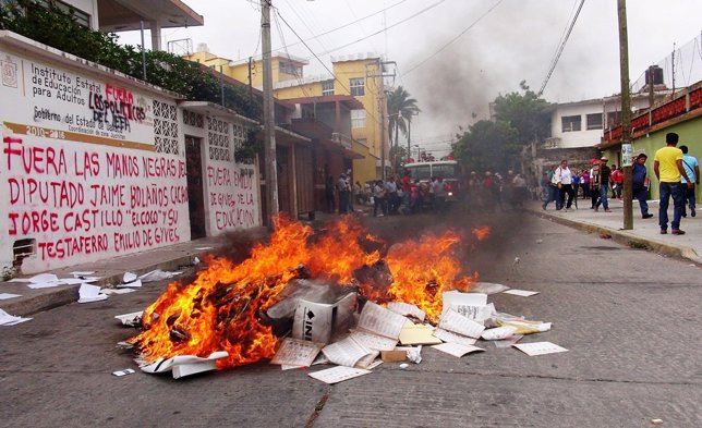 A pile of burning electoral material is seen outside the office of the National 
