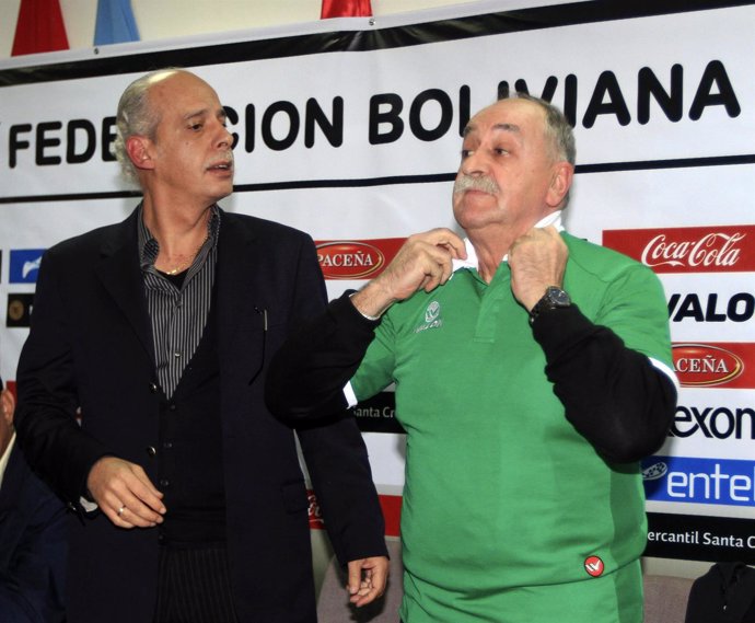 Xavier Azkargorta of Spain adjusts a Bolivia's soccer jersey after being appoint