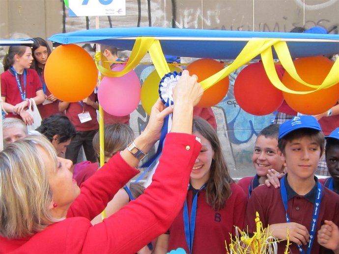 Teresa Fernández (Ibercaja) coloca escarapela a la cooperativa escolar ganadora